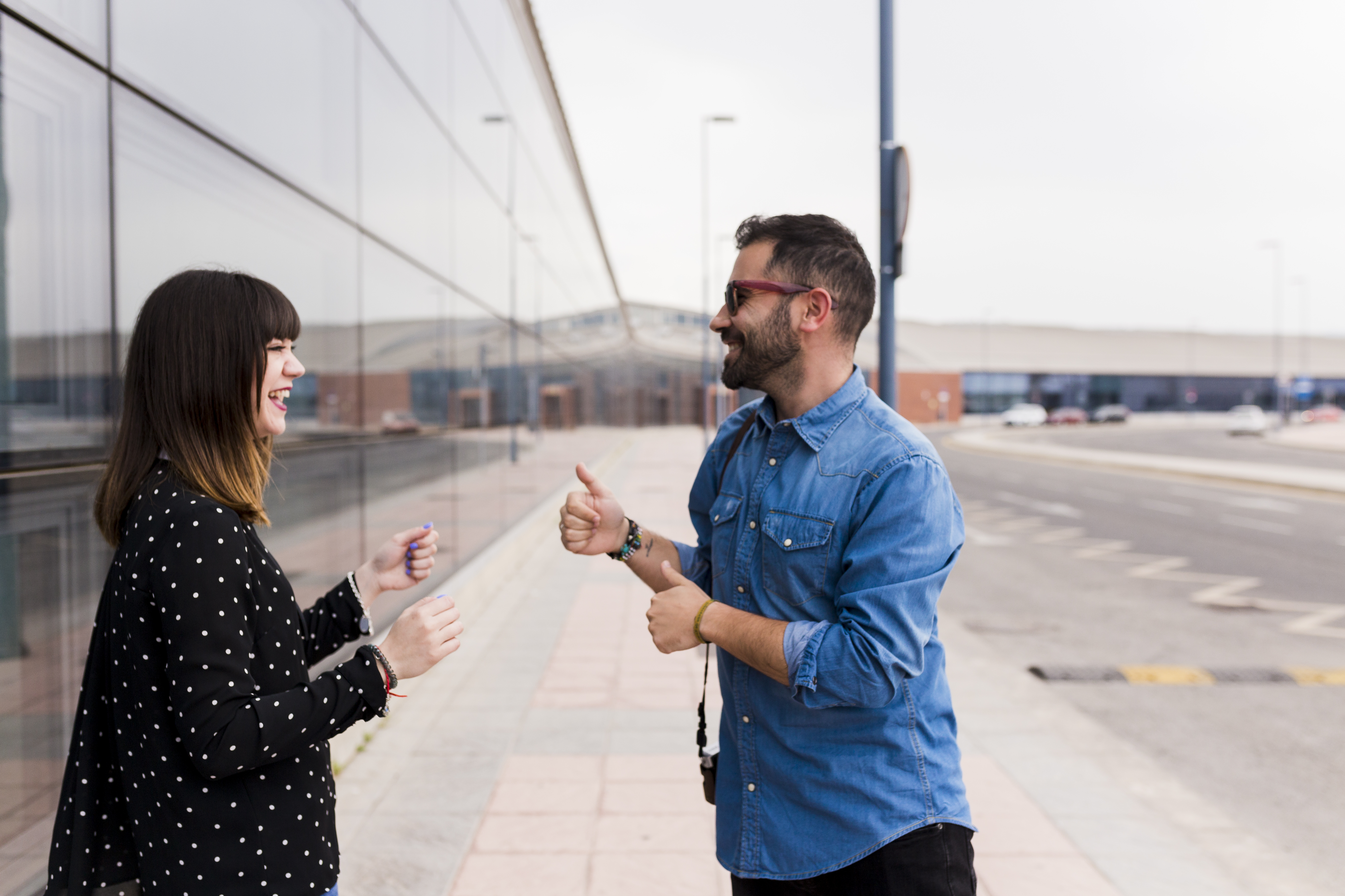 man-showing-thumb-up-sign-her-girlfriend